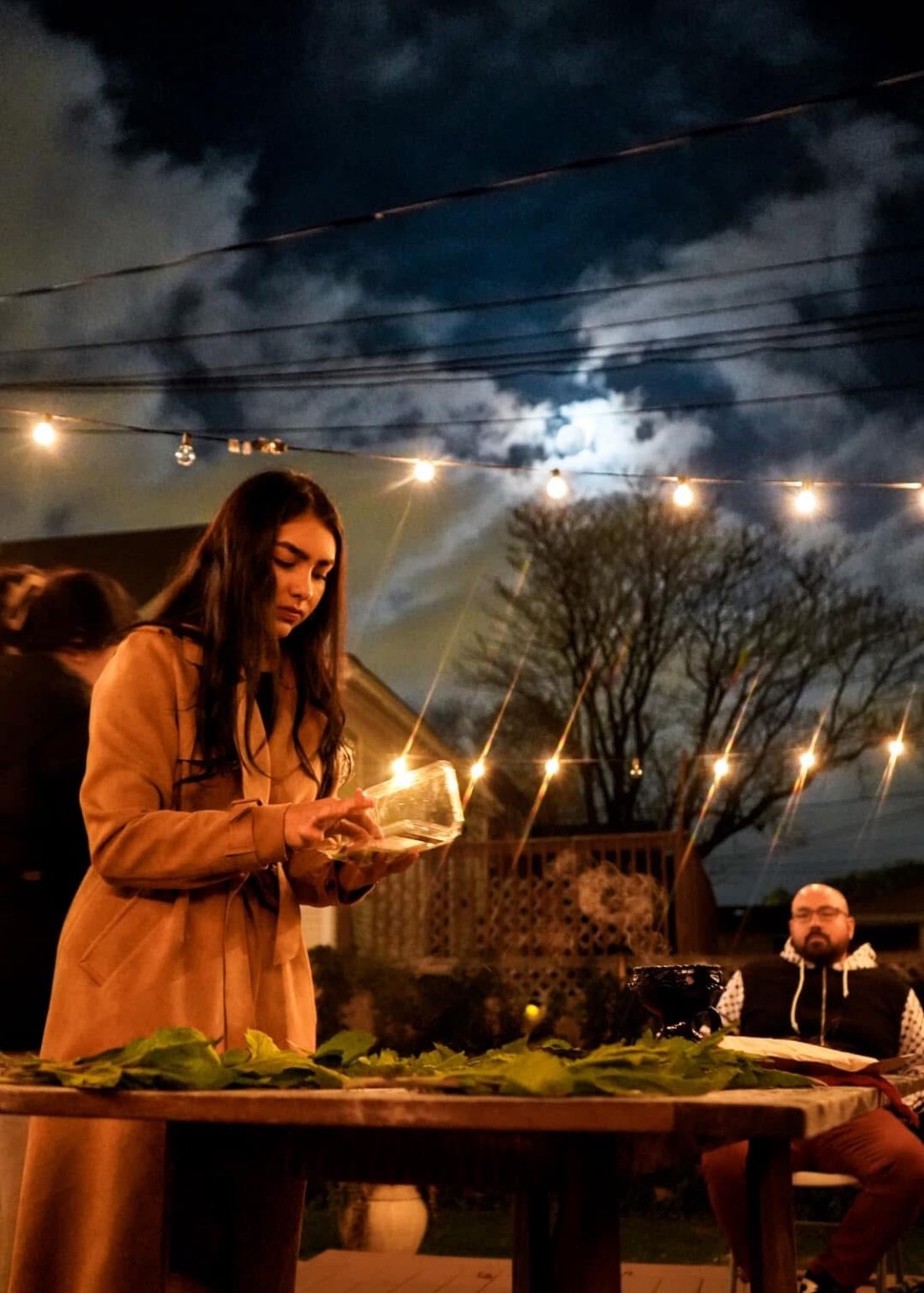 Marcela lighting a candle at a community event